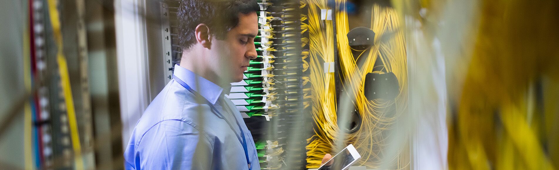 man looking at a tablet surrounded by wires